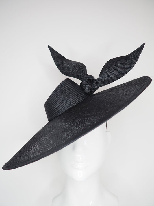 Derby Pose-  Slanted brim parisissal straw with asymmetric crown and wires knot detail